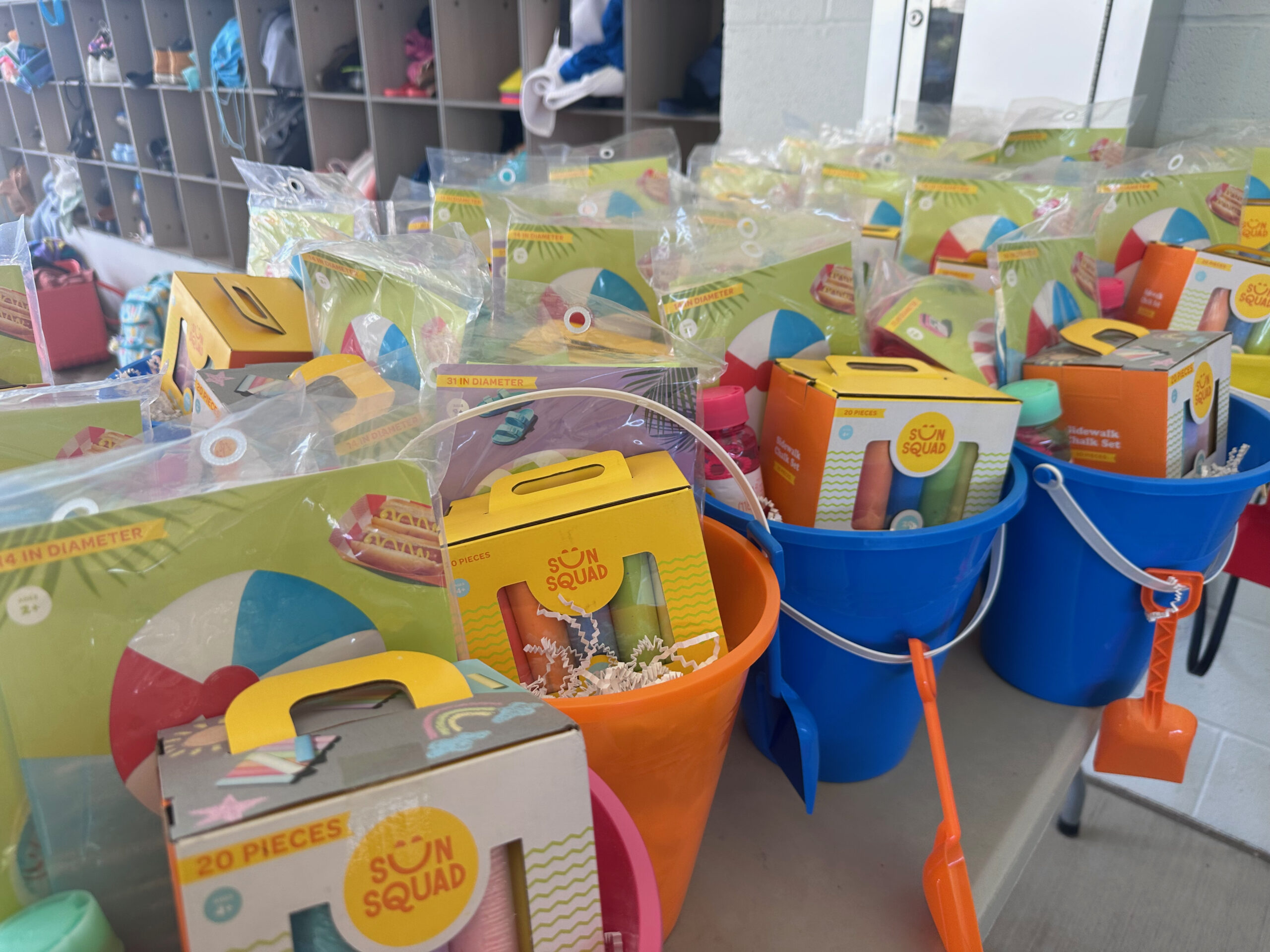 colorful buckets filled with sidewalk chalk beach ball and bubbles